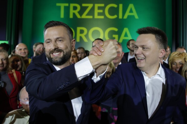 Wladyslaw Kosiniak-Kamysz, left, and Szymon Holownia, laders of the Third Way, a coalition of the centrist Poland 2050 party and the agrarian Polish People's Party greet supporters at their electoral headquarters in Warsaw, Poland, Sunday, Oct. 15, 2023. Poland's election result is on a knife edge as an exit poll says that the governing Law and Justice party won the most votes. Three opposition parties, Civic Coalition, Third Way and the New Left, ran on separate tickets but with the same promises of seeking to oust Law and Justice and restore good ties with the European Union. (AP Photo/Michal Dyjuk)