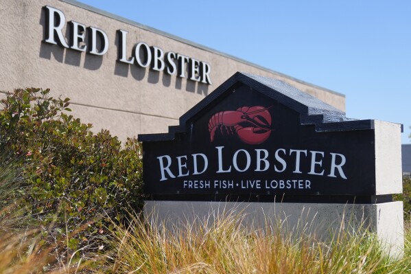 FILE - Signs for a Red Lobster restaurant are shown in San Bruno, Calif., Tuesday, May 14, 2024. Red Lobster has filed for Chapter 11 bankruptcy protection days after shuttering dozens of restaurants. The seafood chain has been struggling for some time with lease and labor costs piling up in recent years and also promotions like its iconic all-you-can-eat shrimp deal. (AP Photo/Jeff Chiu, File)