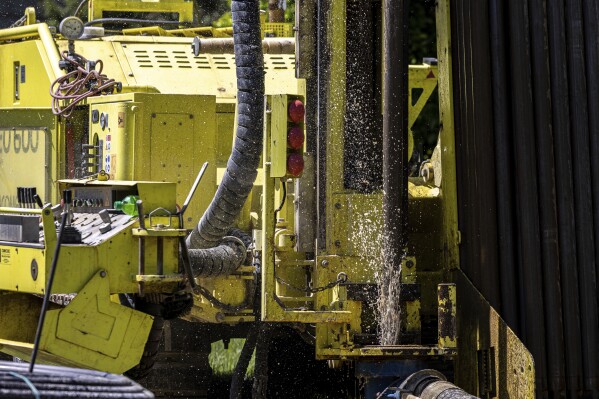 Groundwater squirts up during drilling for a geothermal heating and cooling system at a home in White Plains, N.Y., Monday, May 8, 2023. A water-filled loop installed several hundred feet deep either carries heat away from, or into the house, depending on the season. Industry experts see the technology becoming increasingly popular in the coming years. (AP Photo/Julia Nikhinson)