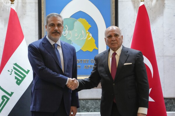 FILE - Iraqi Foreign Minister Fuad Hussein, right, shakes hands with visiting Turkish Foreign Affairs Minister Hakan Fidan in Baghdad, Iraq, Thursday, March 14, 2024. Turkey carried out a new round of airstrikes targeting Kurdish militants in neighboring Iraq on Tuesday, March 19, Turkey’s defense ministry said, hours after a Turkish soldier was killed and four others were wounded in an attack in the region. (AP Photo/Hadi Mizban, File)