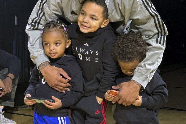 Milwaukee Bucks point guard Damian Lillard poses with his children at an event on Tuesday, Jan. 30, 2024 in Portland, Ore. Lillard was playing in Portland for the first time since he was traded from the Trail Blazers to the Bucks in the offseason. (AP Photo/Anne M. Peterson)