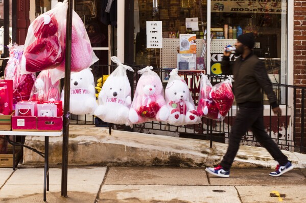 FILE - A pedestrian passes Valentine's day stuffed animals for sale ahead of the holiday in Philadelphia, Feb. 13, 2019. This is the first Valentine's Day since the U.S. surgeon general issued a public health advisory declaring loneliness and isolation an epidemic with dire consequences. (APPhoto/Matt Rourke, file)