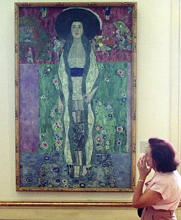 FILE - A woman looks at a purple-hued painting of Adele Block-Bauer by famed Austrian artist Gustav Klimt at the Belvedere palace in Vienna on Sept. 24 1999. The family of Bloch-Bauer fled Austria after the Nazis seized power in 1938. (AP Photo/Rudi Blaha, File)
