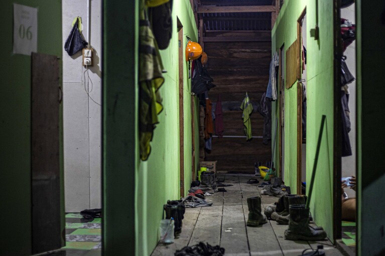Shoes are left outside the rooms at the dormitory for construction workers at the Kalimantan Industrial Park Indonesia (KIPI) in Kampung Baru village, North Kalimantan, Indonesia on Thursday, Aug. 24, 2023. (AP Photo/Yusuf Wahil)