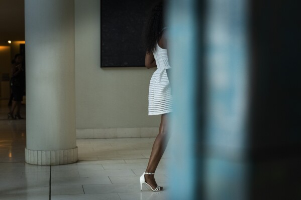 A fashionista makes her way at the start of Johannesburg Fashion Week 2023 in Johannesburg, South Africa, Wednesday, Nov. 8, 2023. (AP Photo/Jerome Delay)