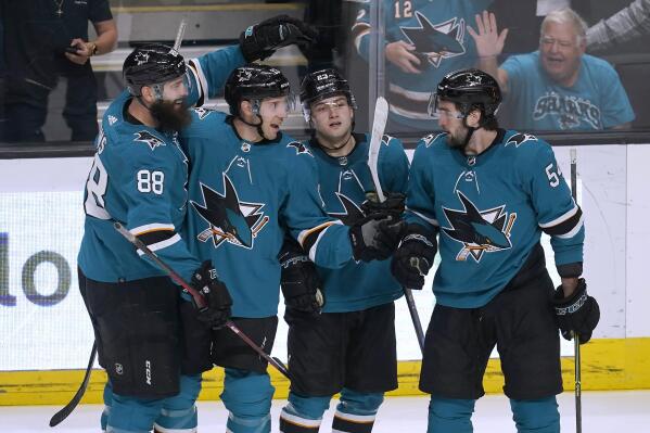 San Jose Sharks center Nick Bonino, center left, is congratulated by defenseman Brent Burns (88), center Thomas Bordeleau, center right, and center Scott Reedy (54) after scoring against the Chicago Blackhawks during the third period of an NHL hockey game in San Jose, Calif., Saturday, April 23, 2022. (AP Photo/Jeff Chiu)
