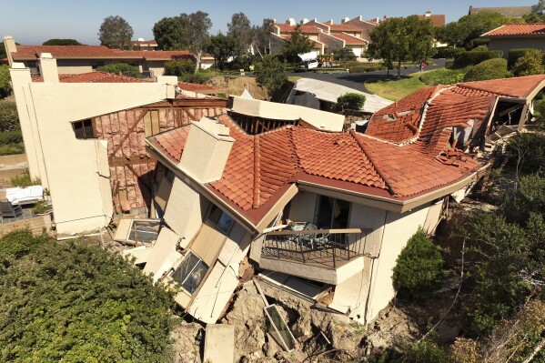 This photo taken with a drone shows damage from earth movement to a property in Rolling Hills Estates, Calif., Monday, July 10, 2023. The homes in the Los Angeles County city of Rolling Hills Estates were hastily evacuated by firefighters Saturday when cracks began appearing in structures and the ground. (Ted Soqui via AP)
