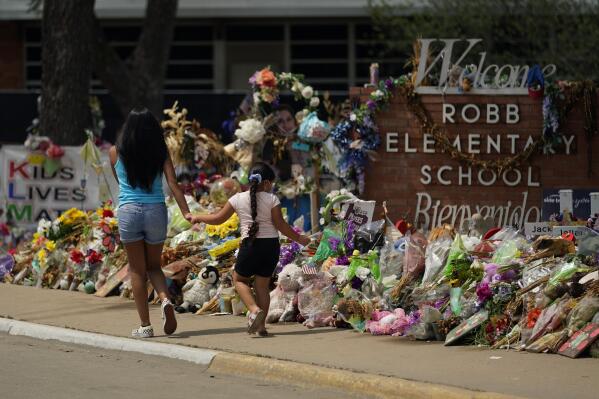 n this July 12, 2022, photo, Visitors walk past a makeshift memorial honoring those killed at Robb Elementary School, in Uvalde, Texas. Parents in Uvalde, Texas, are livid about the security lapses that contributed to the school shooting this spring. They're terrified to send their kids back to school. Yet further securing schools -- such as through additional lockdown drills -- is controversial. (AP Photo/Eric Gay, FILE)