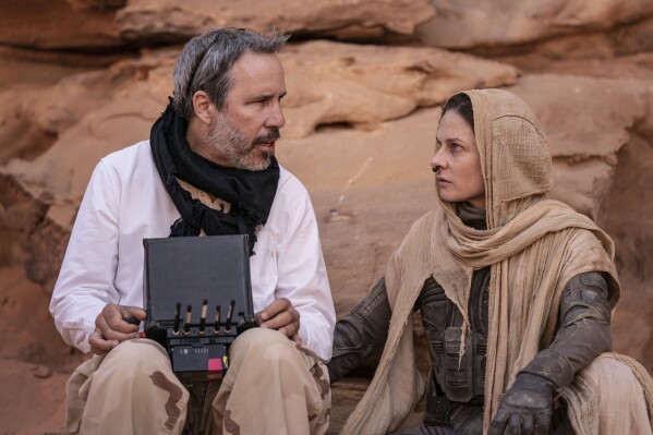 This image released by Warner Bros. Pictures shows director Denis Villeneuve, left, with actor Rebecca Ferguson on the set of "Dune: Part Two." (Niko Tavernise/Warner Bros. Pictures via AP)