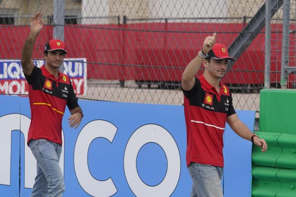 FILE - Ferrari drivers Charles Leclerc, of Monaco, right, and Carlos Sainz, of Spain, left, are introduced before the Formula One U.S. Grand Prix auto race at the Circuit of the Americas, on Oct. 23, 2022, in Austin, Texas. Several hundred fans, a coin toss and an iconic red car already on the track — it wasn’t the usual Formula One car presentation for Ferrari on Tuesday, Feb. 14, 2023. In front of a grandstand packed with about 500 passionate red-clad fans, drivers Charles Leclerc and Carlos Sainz Jr. did laps of Ferrari’s Fiorano track in the new SF-23 car. (AP Photo/Darron Cummings)