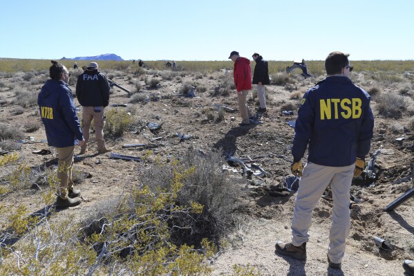 FILE - NTSB investigators survey the site of an Airbus Helicopters EC-130 on Sunday, Feb. 11, 2024, near Halloran Springs, Calif. The crash in the Mojave Desert killed, Herbert Wigwe, CEO of one of Nigeria's largest banks along with his wife and son. Investigators with the National Transportation Safety Board say, Friday, Feb. 23, 2024, the helicopter left a shallow crater when it crashed earlier this month in Southern California鈥檚 Mojave Desert. (Peter Knudson/NTSB via AP)