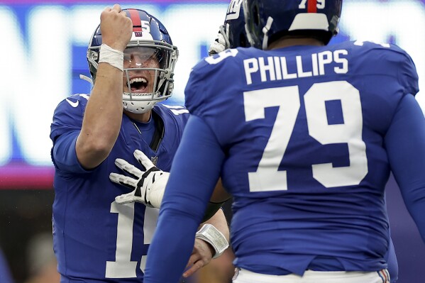 New York Giants quarterback Tommy DeVito (15) celebrates after throwing a touchdown pass against the New England Patriots during the second quarter of an NFL football game, Sunday, Nov. 26, 2023, in East Rutherford, N.J. (AP Photo/Adam Hunger)