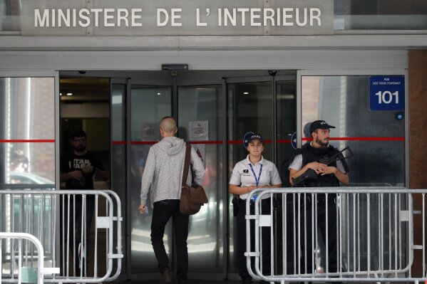 Police officers guard the Anti-Corruption Office of the Judicial Police headquarters in Nanterre, outside Paris,Tuesday, June 18, 2019. Former UEFA president Michel Platini has been arrested in relation to a corruption probe into the awarding of the 2022 World Cup to Qatar, a judicial official said Tuesday. (AP Photo/Christophe Ena)