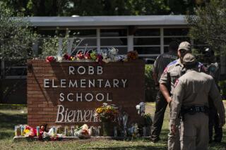 Flowers and candles are placed outside Robb Elementary School in Uvalde, Texas, Wednesday, May 25, 2022, to honor the victims killed in Tuesday's shooting at the school. Social media users have made misleading claims about Texas handgun laws following the shooting. (AP Photo/Jae C. Hong)