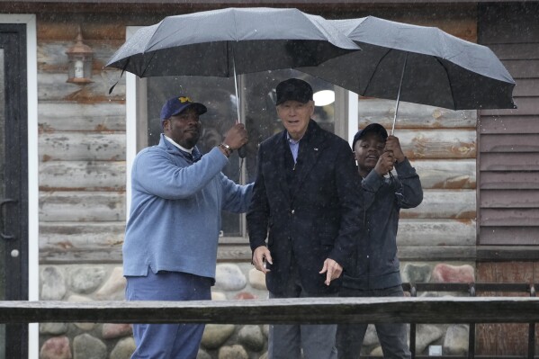 President Joe Biden poses for a photo with Hurley "HJ" Coleman IV and his father Hurley Coleman III, left, as he arrives for a campaign event at Pleasant View Golf Club in Saginaw, Mich., Thursday, March 14, 2024. (AP Photo/Jacquelyn Martin)