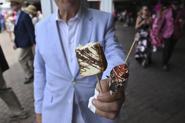 A person holds treats at Churchill Downs before the 151st running of the Kentucky Oaks horse race Friday, May 2, 2025, in Louisville, Ky. (AP Photo/Jon Cherry)