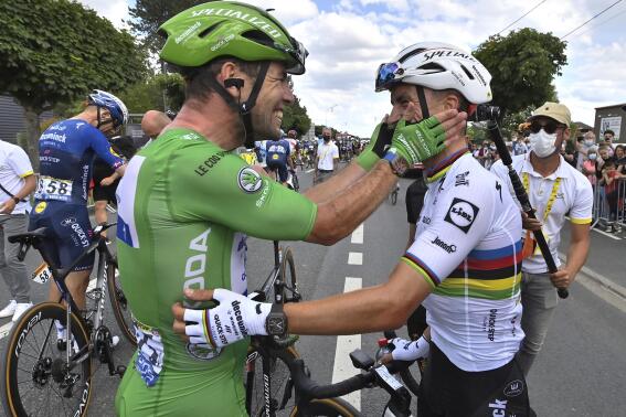 FIE - Britain's Mark Cavendish, wearing the best sprinter's green, celebrates with France's Julian Alaphilippe after winning the sixth stage of the Tour de France cycling race over 160.6 kilometers (99.8 miles) with start in Tours and finish in Chateauroux, France, on July 1, 2021. Two-time world champion Julian Alaphilippe and ace sprinter Mark Cavendish won't be on the starting line when the Tour de France kicks off Friday from Copenhagen. (David Stockman, Pool Photo via AP)