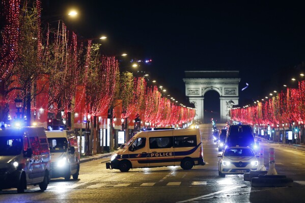 FILE - Police vans are parked on the Champs Elysees avenue during the New Year's Eve, in Paris, Thursday, Dec. 31, 2020. Security will be tight across France on New Year's Eve, with 90,000 law enforcement officers set to be deployed throughout the country, domestic intelligence chief Céline Berthon said Friday Dec.29, 2023. 6,000 will be deployed in Paris, where French Interior Minister Gerald Darmanin said over 1.5 million are expected to attend celebrations on the Champs-Elysees. (AP Photo/Thibault Camus, File)
