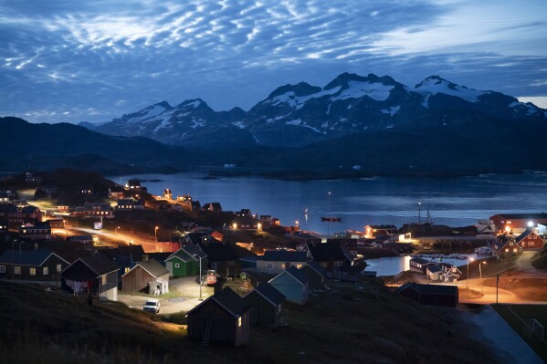 FILE - Homes are illuminated after the sunset in Tasiilaq, Greenland, Friday Aug. 16, 2019. A group of 143 Greenlandic women have sued the Danish state for having been fitted with coils in the 1960s and 1970s, and demand a total compensation of nearly 43 million kroner ($6.3 million), Danish broadcaster DR reported Monday, March 4, 2024.(AP Photo/Felipe Dana, File)