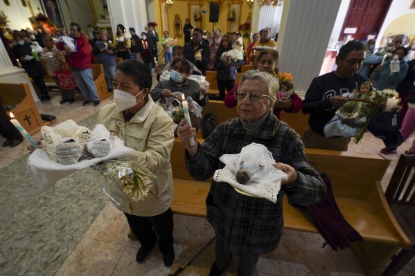 FILE - People hold up their baby Jesus figurines at church for a blessing on Candlemas Day, in Mexico City, Feb. 2, 2024. According to the latest official report (2020), 98 million of 126 million Mexicans are Catholics. (AP Photo/Marco Ugarte, File)
