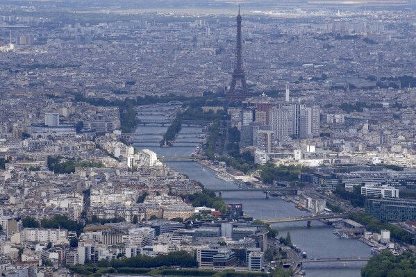 The Seine rivers flows though Paris, with the Eiffel Tower at center, in Paris, Tuesday, July 11, 2023. Heavy rains in Paris have dealt a blow to plans intended to test the French capital's readiness for swimmers to race in the River Seine at next year's Summer Olympics. A planned training session Friday Aug.4, 2023 for swimmers aiming to compete this weekend in the river that cuts through Paris was cancelled because the water quality dropped below acceptable standards.(AP Photo/Christophe Ena)