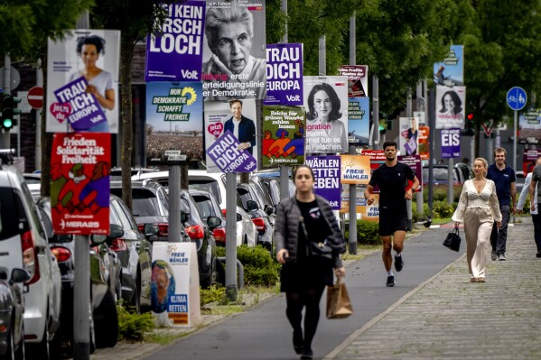 People walk past elections posters for the European elections in Frankfurt, Germany, Thursday, June 6, 2024. (AP Photo/Michael Probst)