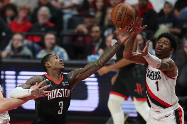 Houston Rockets guard Kevin Porter Jr., left, and Portland Trail Blazers guard Anfernee Simons, right, reach for a rebound during the first quarter of an NBA basketball game in Portland, Ore., Friday, Oct. 28, 2022. (AP Photo/Steve Dipaola)
