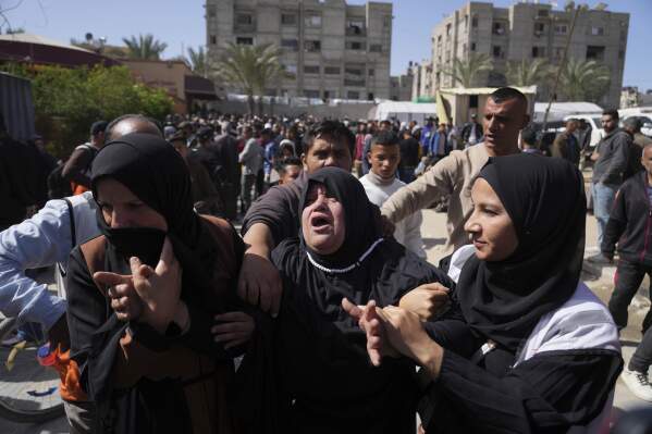 Mourners react during the funeral of 8 Red Crescent emergency responders, recovered in Rafah a week after an Israeli attack, in Deir al-Balah, Gaza Strip, on Monday, March 31, 2025. (AP Photo/Abdel Kareem Hana)