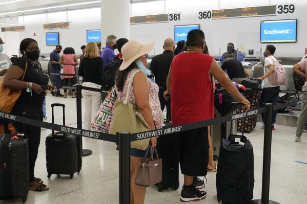 Southwest passengers wait to check in at Miami International Airport, Tuesday, Oct. 12, 2021, in Miami. Southwest Airlines appears to be fixing problems that caused the cancellation of nearly 2,400 flights over the previous three days. By midday Tuesday, Southwest had canceled fewer than 100 flights, although more than 400 others were running late. (AP Photo/Marta Lavandier)