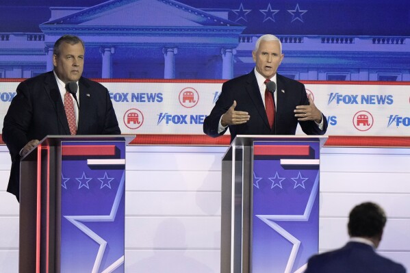 Former Vice President Mike Pence speaks as former New Jersey Gov. Chris Christie listens during a Republican presidential primary debate hosted by FOX News Channel Wednesday, Aug. 23, 2023, in Milwaukee. (AP Photo/Morry Gash)