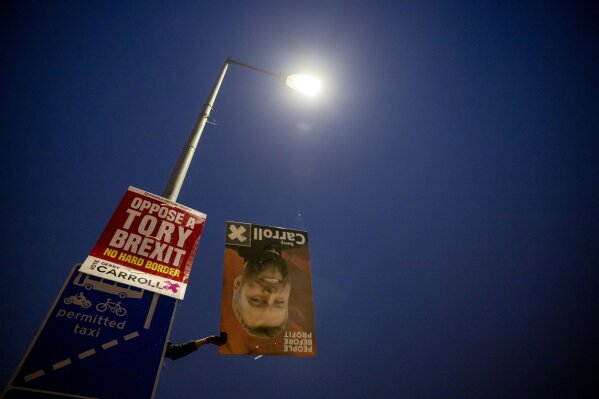 A campaign poster is taken down following the U.K.'s general election Friday, Dec. 20, 2019, in Belfast, Northern Ireland. On Jan. 31, the U.K. will be leaving the European Union and questions still remain about what a post Brexit world will look like along the Irish border for both Catholics and Protestants. (AP Photo/David Goldman)