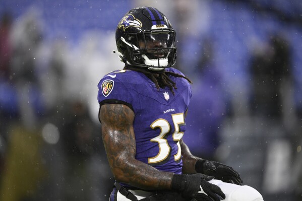 FILE - Baltimore Ravens running back Gus Edwards works out before an NFL football game against the Pittsburgh Steelers, Jan. 6, 2024, in Baltimore. Jim Harbaugh said upgrading the running game would be a major focus when he was hired as the Los Angeles Chargers' coach. The Bolts took a major step in that direction by agreeing to terms with Ravens running back Edwards. (AP Photo/Nick Wass, File)