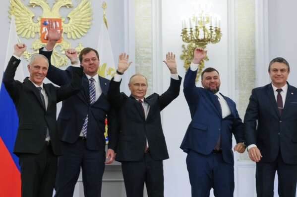 From left, Vladimir Saldo, Yevgeny Balitsky, Vladimir Putin, center, Denis Pushilin and Leonid Pasechnik wave during a Kremlin ceremony on Sept. 30, 2022, for Russia to annex four regions of Ukraine that it seized at the Kremlin in Moscow. (Mikhail Metzel, Sputnik, Kremlin Pool Photo via AP, File)
