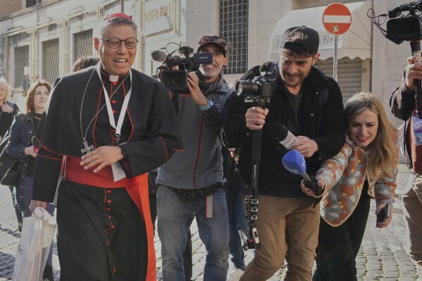 Cardinal Stephen Chow Sau-yan is approached by reporters as he arrives for a college of cardinals' meeting, at the Vatican, Wednesday, April 30, 2025. (AP Photo/Gregorio Borgia)