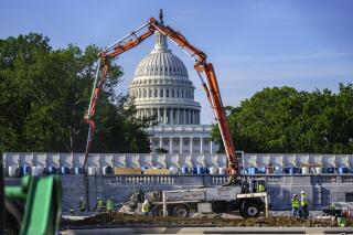 FILE - A concrete pump frames the Capitol Dome during renovations and repairs to Lower Senate Park on Capitol Hill in Washington, Tuesday, May 18, 2021. Plans to pump money into rebuilding the nation’s roads, bridges and other infrastructure could give companies that make machinery and materials a solid foundation for growth. (AP Photo/J. Scott Applewhite, file)
