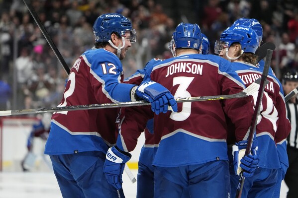 Colorado Avalanche center Ryan Johansen, left, celebrates after scoring a goal with defenseman Jack Johnson, center, and left wing Joel Kiviranta in the third period of an NHL hockey game against the Vancouver Canucks Tuesday, Feb. 20, 2024, in Denver. (AP Photo/David Zalubowski)