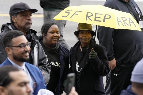 FILE - Pia Harris, with the San Francisco Housing Development Corporation, second from left, and her mother, Adrian Williams, listen to speakers at a reparations rally outside of City Hall in San Francisco, Tuesday, March 14, 2023. Harris hopes for reparations in her lifetime. But the nonprofit program director is not confident that California lawmakers will turn the recommendations of a first-in-the-nation task force into concrete legislation, given the pushback from opponents who say slavery was a thing of the past. (APPhoto/Jeff Chiu, File)