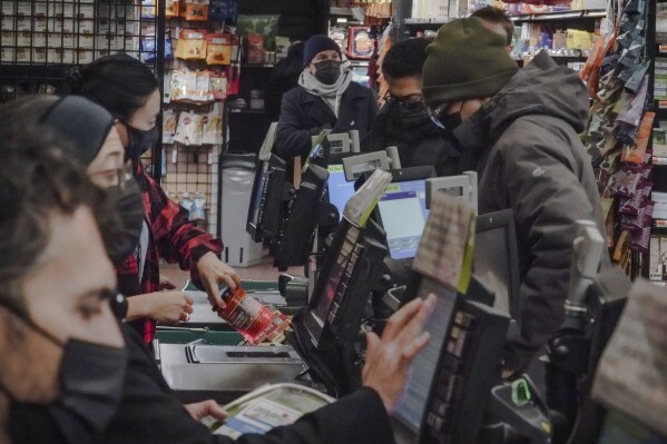 Store clerks and shoppers wear masks at the Park Slope Co-op grocery store in Brooklyn on Thursday, Dec. 7, 2023, in New York.  (AP Photo/Bebeto Mathews)