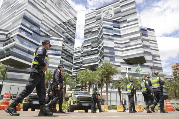 Police walk outside Federal Police headquarters in Brasilia, Brazil, Wednesday, April 5, 2023. Brazil's former President Jair Bolsonaro entered the Federal Police headquarters on Wednesday to be questioned on whether diamond jewelry brought into the country from Saudi Arabia were public gifts that Bolsonaro improperly tried to prevent from being incorporated into the presidency’s public collection, or private gifts that Bolsonaro tried sneak into Brazil without paying taxes. Bolsonaro has repeatedly denied any wrongdoing connected to the gifts.(AP Photo/Gustavo Moreno)