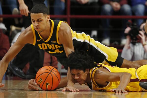 Iowa forward Kris Murray, top, vies for the ball with Minnesota guard Jaden Henley in the first half of an NCAA college basketball game Sunday, Feb. 12, 2023, in Minneapolis. (AP Photo/Bruce Kluckhohn)