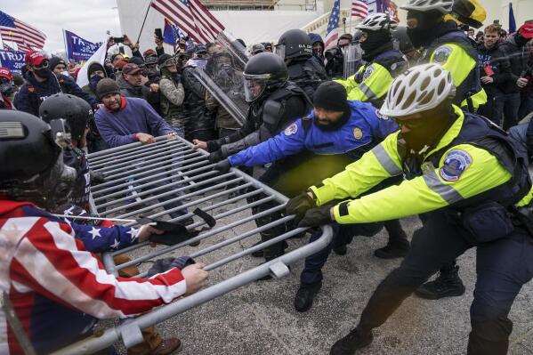 FILE - In this Jan. 6, 2021, file photo violent insurrectionists loyal to President Donald Trump hold on to a police barrier at the Capitol in Washington.  (AP Photo/John Minchillo, File)
