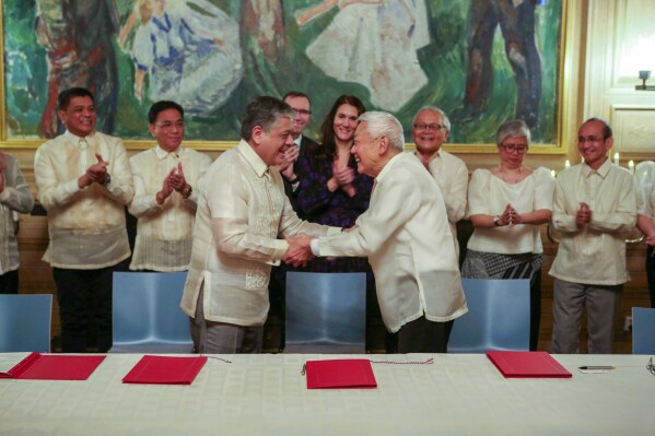 Special Adviser to the President, Minister Antonio Lagdameo, center, and Luis Jalandoni of the Communist Movement (NDFP) shake hands after signing their joint vision for peace, at Oslo City Hall, on Thursday, Nov. 23, 2023. The Philippine government and the country鈥檚 communist rebels have agreed to resume talks aimed at ending decades of armed conflict, one of Asia's longest, Norwegian mediators announced Tuesday, Nov. 28, 2023. High-ranking delegations from both sides met in the Norwegian capital last week and agreed to a 鈥渃ommon vision for peace鈥� that sought to address key obstacles, according to Norway鈥檚 foreign ministry. (Mathias Rongved/Norwegian Ministry of Foreign Affairs via NTB)