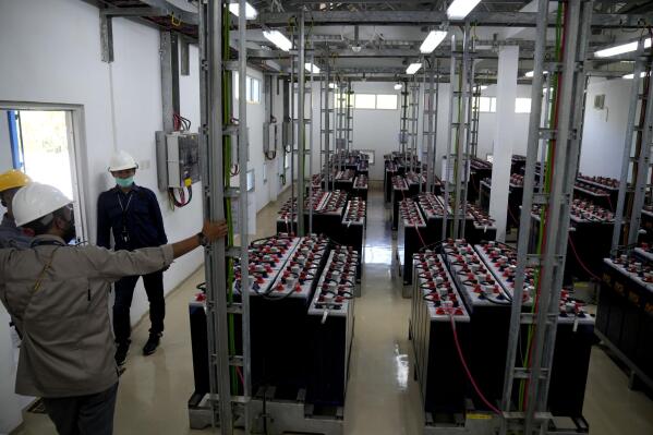 Workers talk in a battery room at a solar power plant on Karampuang Island, in West Sulawesi, Indonesia, Thursday, Dec. 22, 2022. While Indonesia has vast renewable and green energy potential from solar, wind, geothermal and other sources, experts warn that the vast archipelago nation faces unique financial, policy, infrastructure and other challenges that will require innovation.(AP Photo/Dita Alangkara)