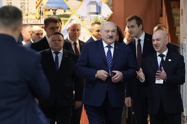 In this photo provided by the Belarusian Presidential Press Service, Belarus President Alexander Lukashenko, centre, walks ahead of voting at a polling station in Minsk, Belarus, on Sunday, Feb. 25, 2024. Lukashenko was believed a few years ago to be considering whether to lead the new body after stepping down, but his calculus has apparently changed, and he announced on Sunday that he will run in next year's presidential election. (Belarusian Presidential Press Service via AP)