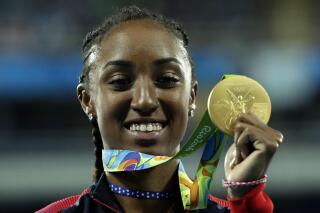 FILE - In this Thursday, Aug. 18, 2016 file photo, Gold medal winner Brianna Rollins from the United States shows off her medal during the medal ceremony for the women's 100-meter hurdles final during the athletics competitions of the 2016 Summer Olympics at the Olympic stadium in Rio de Janeiro, Brazil. Brianna Rollins-McNeal has been banned for five years in a doping case it was reported on Friday, June 4, 2021. The decision rules her out of this year's Tokyo Games and the 2024 Paris Games. The Athletics Integrity Unit says the American’s second career ban was for “tampering within the results management process” of doping control samples. The 29-year-old hurdler's ban runs to August 2024. AP Photo/Dmitri Lovetsky, File)