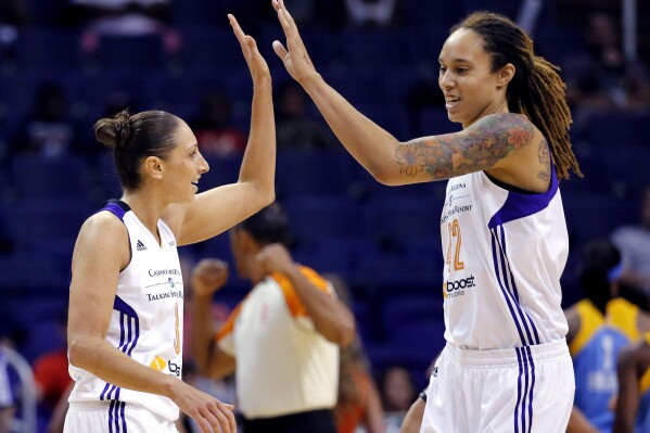 FILE - Phoenix Mercury guard Diana Taurasi, left, high-fives teammate Brittney Griner during the first half of a WNBA basketball game against the Chicago Sky, on July 2, 2014, in Phoenix. Five-time Olympic gold medalist Diana Taurasi and Brittney Griner head up the USA Basketball Women鈥檚 National Team roster of 16 players announced Thursday, Oct. 26, 2023, for a pair of November exhibition games and training camp in Atlanta.(APPhoto/Matt York, File)
