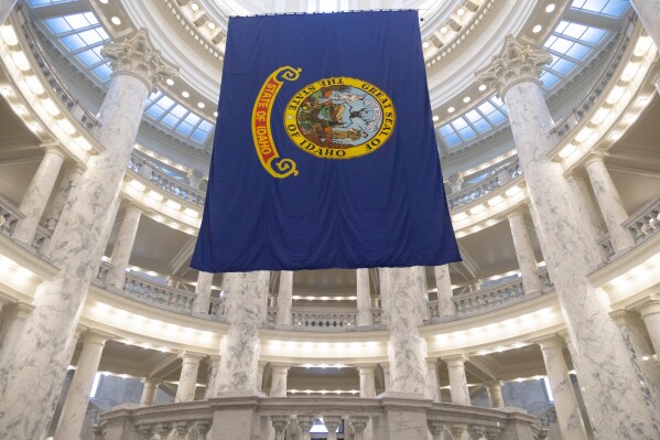 FILE - The Idaho state flag hangs in the State Capitol in Boise, Idaho, Jan. 9, 2023. Idaho Republicans will gather in presidential caucuses Saturday, March 2, 2024, to help pick their party's presidential standard-bearer. Former president Donald Trump and former UN Ambassador Nikki Haley will compete for the state's 32 Republican delegates, as will Texas businessman and pastor Ryan Binkley. (AP Photo/Kyle Green, File)