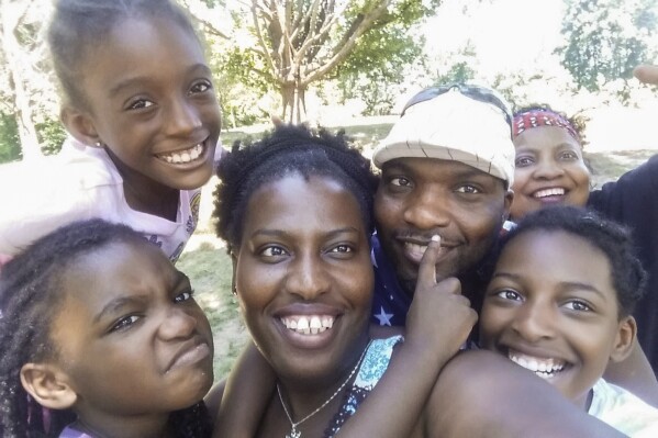 In this photo provided by Sharline Volcy, Volcy, her husband Ronald Donat, their two daughters and two other relatives pose for a photo at a 2016 family picnic in West Orange, N.J. (Sharline Volcy via AP)