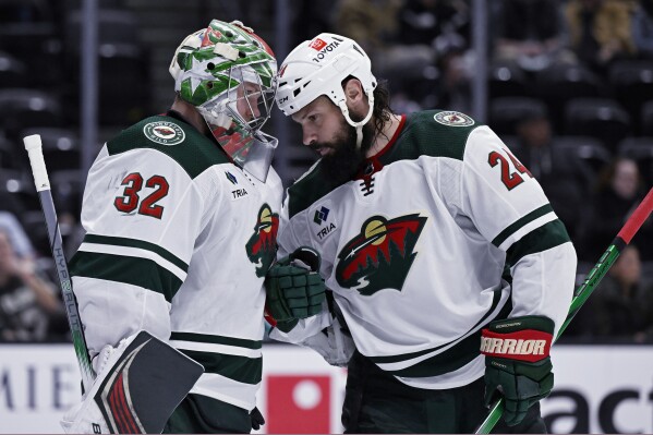 Minnesota Wild goaltender Filip Gustavsson (32) celebrates with defenseman Zach Bogosian (24) after the Wild defeated the Anaheim Ducks in an NHL hockey game in Anaheim, Calif., Tuesday, March 19, 2024. (AP Photo/Alex Gallardo)