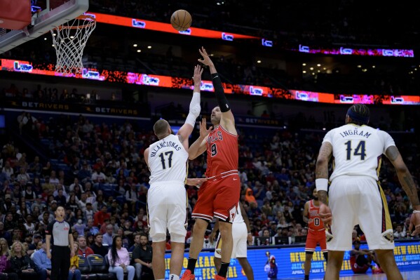 Chicago Bulls center Nikola Vucevic (9) shoots over New Orleans Pelicans center Jonas Valanciunas (17) during the first half of an NBA basketball game in New Orleans, Sunday, Feb. 25, 2024. (AP Photo/Matthew Hinton)